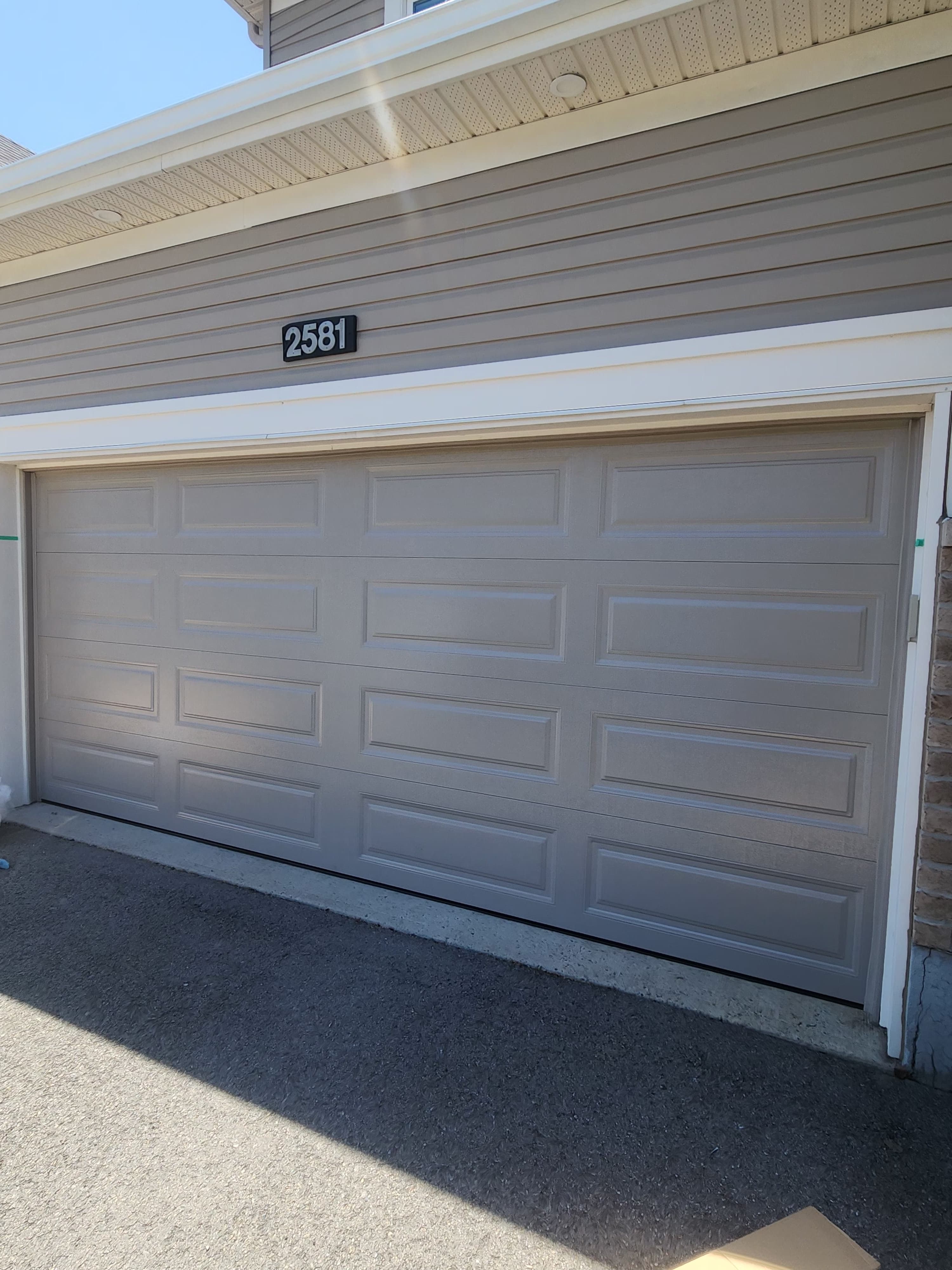 New garage door installation in Barrhaven subdivision — steel sectional door