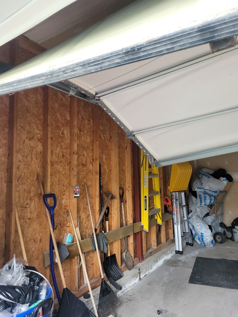 Garage door off track and hanging at an angle — emergency garage door repair in Ottawa